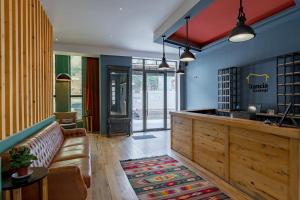 una hall ristorante con divano e bar di Hotel Stancia Kazbegi - City Center a Kazbegi