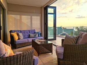 a living room with a purple couch and chairs at Die Braaihuis, sleeps 6, Central and Fabulous! in Gordonʼs Bay