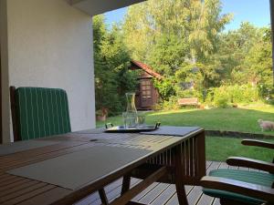 a wooden table on a deck with a view of a yard at Dom nad jeziorem Tajty in Giżycko