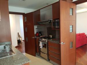a kitchen with brown cabinets and a stove top oven at BlueZone Apartments in Quito
