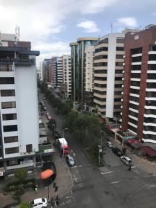 una calle de la ciudad con coches y edificios aparcados en BlueZone Apartments, en Quito
