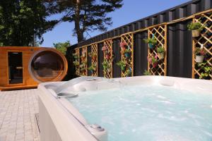 a hot tub on a patio with potted plants at Appartementhaus Schleiblick in Kappeln