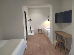 a room with two beds and a table and a television at Yasemi in Argostoli