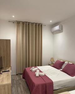 een slaapkamer met een bed met twee handdoeken erop bij Deni's Hotel in Sarandë