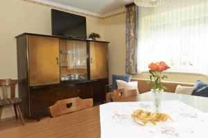 una sala da pranzo con tavolo e mobile con televisore di Ferienhaus Jantscher a Flattach