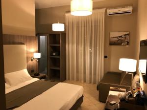 una habitación de hotel con una cama y un sofá en Napoli Com'era, en Nápoles