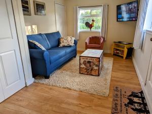 a living room with a blue couch and a table at The Cottage on the Farm in Ladysmith