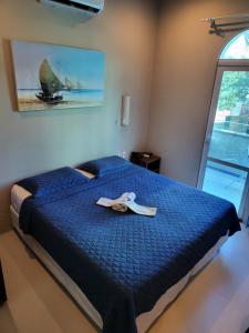 Una cama con un edredón azul y un par de zapatos encima. en Hotel Encontro do Sol, en Fortaleza 37 fotos más