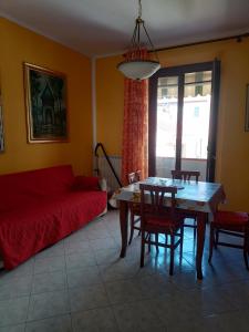 een woonkamer met een rode bank en een tafel bij Casa centro Piombino in Piombino