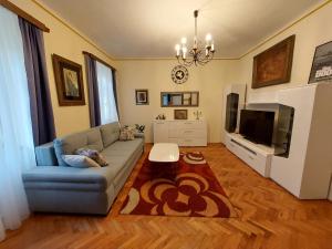 a living room with a couch and a flat screen tv at APP Old Garden House in Šibenik