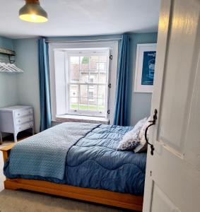 a bedroom with a bed and a window at Bluebird Cottage in Pickering