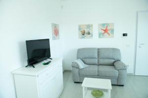 sala de estar con sofá y TV en Casa Luigi en Golfo Aranci
