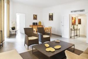 a living room with a table and chairs at Cannes Croisette Prestige Apart'hotel in Cannes