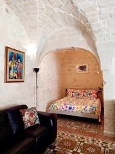 a bedroom with a bed and a couch in a room at Apartment Mammacara in Ceglie Messapica