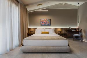 ASKLIPIOS LUXURY ROOMS في نافباكتوس: غرفة نوم بسرير كبير ومكتب