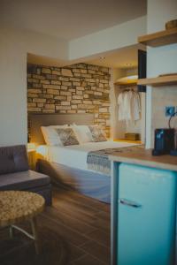 ein Schlafzimmer mit einem Bett und einer Steinmauer in der Unterkunft Peri Elxis Luxury Suites in Mouresi
