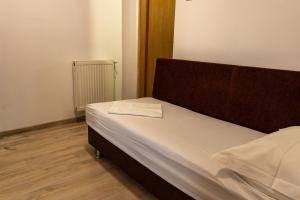 a small bedroom with a bed with a wooden headboard at Vila Blue Marine 2 Mai in 2 Mai