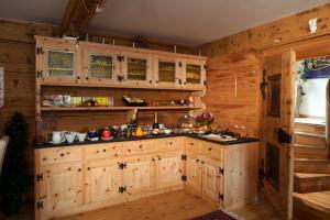 una cocina con paredes de madera y armarios de madera. en Hotel Chasa Sofia en Scuol