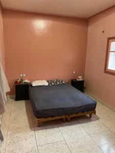 a bedroom with a bed and two night stands at Ferme fes in Fès