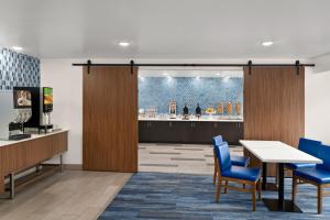 a waiting room with a table and blue chairs at La Quinta Inn by Wyndham Columbus Dublin in Dublin