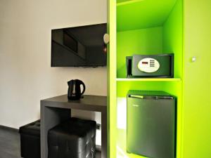 um quarto com uma parede verde com uma mesa e uma televisão em Affittacamere Tiburstation em Roma