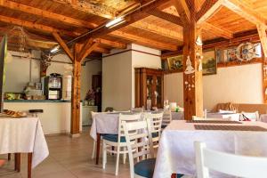 a restaurant with white tables and chairs and wooden ceilings at Vila Blue Marine 2 Mai in 2 Mai