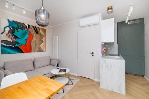 een woonkamer met een bank en een tafel bij Apartament w sercu Gdyni in Gdynia