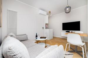 Biały salon z kanapą i telewizorem w obiekcie Apartament w sercu Gdyni w mieście Gdynia
