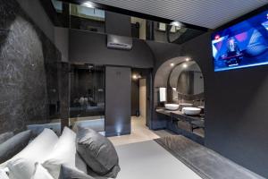 a bathroom with a couch and a tv in a room at 4 Suites " unconventional living rooms " in Catania