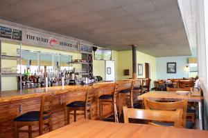 a restaurant with wooden tables and chairs and a bar at Surry Seafood Company in Surry