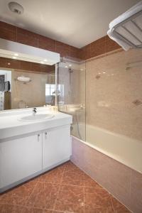 uma casa de banho com um lavatório branco e um chuveiro em Cannes Croisette Prestige Apart'hotel em Cannes