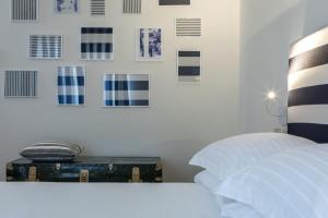 een slaapkamer met een koffer en foto's aan de muur bij Murè Hotel Numana in Numana