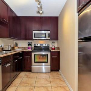 eine Küche mit Holzschränken und einem Edelstahlofen in der Unterkunft Beautiful Apartment with Pool in Miami in Miami