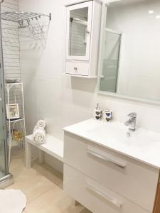 biała łazienka z umywalką i lustrem w obiekcie Benal Beach deluxe apartment with panoramic sea views w mieście Benalmádena