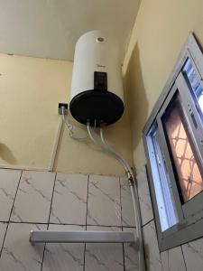 a light on the corner of a bathroom with a tv at Apex guest facility in Buea