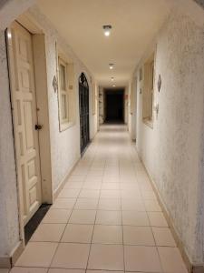 un pasillo vacío con paredes blancas y suelo de baldosa en Hotel Dulce Luna, en San Cristóbal de Las Casas