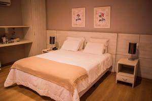 ein Schlafzimmer mit einem großen weißen Bett mit zwei Kissen in der Unterkunft Hotel Marques in Araras