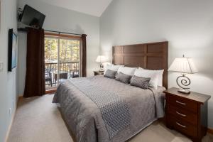 um quarto com uma cama grande e uma varanda em The Residences at Fairmont Ridge em Fairmont Hot Springs