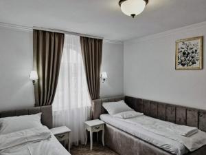 a hotel room with two beds and a window at Mini Paradis in Oradea +16 photos