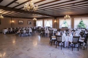 um salão de banquetes com mesas, cadeiras e lustres em Hotel Scala em Padrón