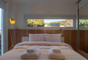 sypialnia z dużym łóżkiem z dwoma ręcznikami w obiekcie MIRADORES DEL SUSANA DUPLEX I w mieście Ushuaia