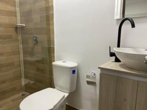 Aparta Suites 503 Granada Cali في كالي: حمام مع مرحاض ومغسلة