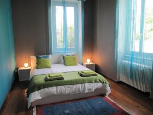 a bedroom with a large bed with two windows at Villa Art'è in Locarno