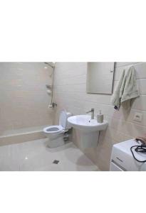 biała łazienka z toaletą i umywalką w obiekcie Geo Kutaisi w Kutaisi