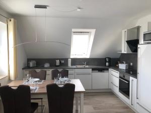 a kitchen with a table and chairs in it at Greetje Oog in Krummhörn