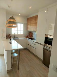 a kitchen with white cabinets and a white counter top at T1 Praia de Altura in Altura