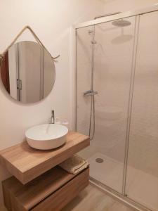 a bathroom with a sink and a shower with a mirror at T1 Praia de Altura in Altura