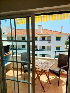een balkon met een tafel en stoelen en uitzicht op een gebouw bij T1 Praia de Altura in Altura