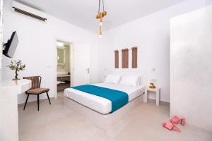 a white bedroom with a bed and a desk at Villa Echedra in Vlychada +93 photos