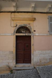 une porte brune sur le côté du bâtiment dans l'établissement Casa Domenica, à Corfou